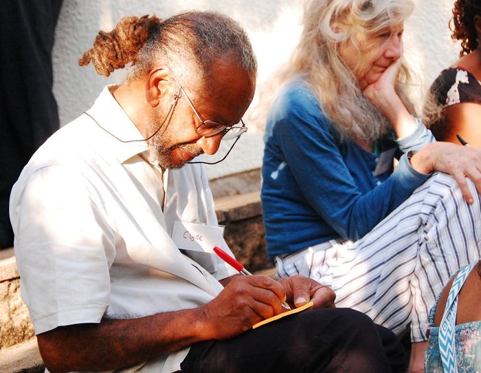 A guest writing on a note during the evening, with others sitting alongside him.